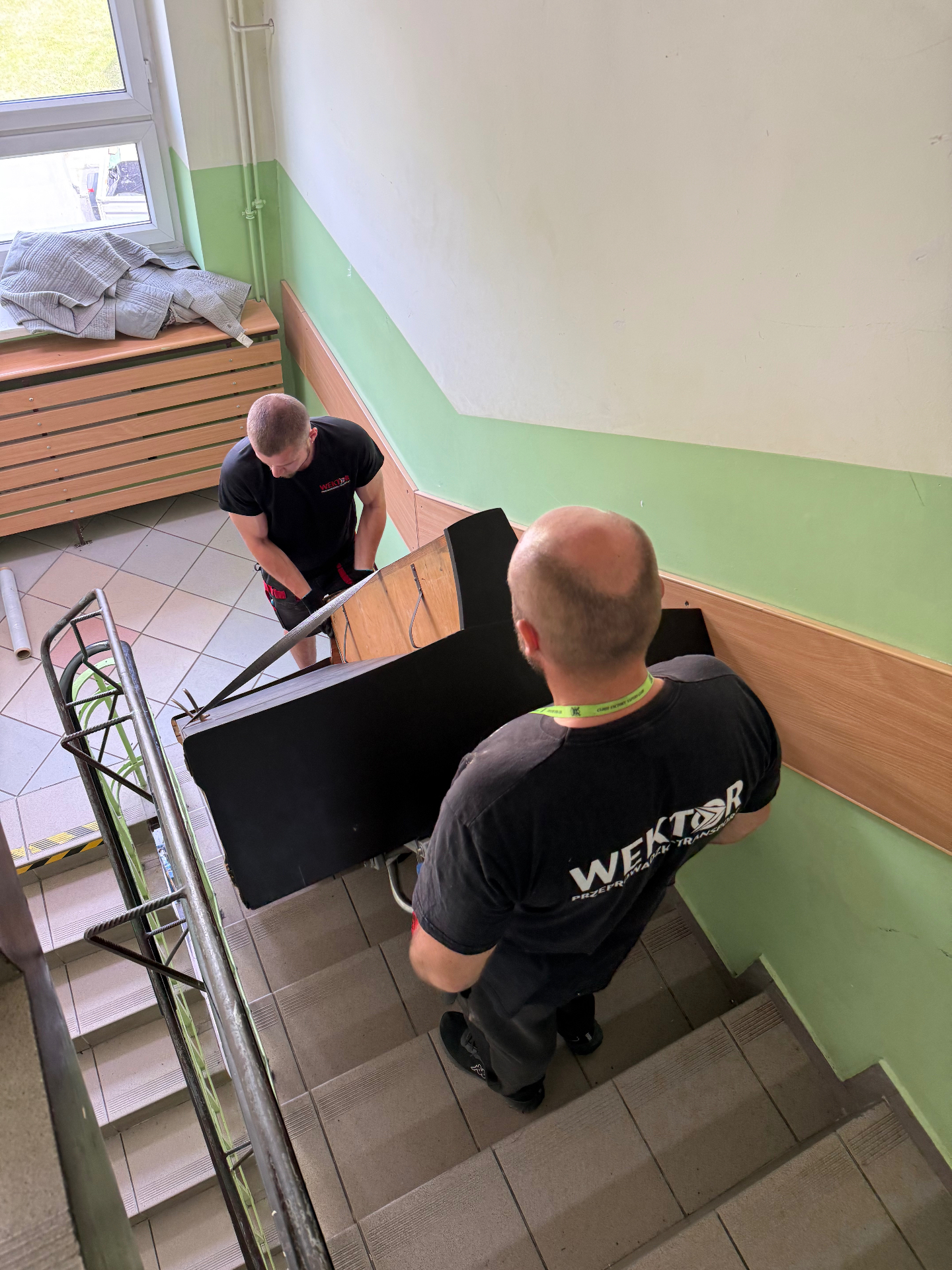 Ekipa Wektor niesie pianino schodołazem po schodach — Szczecin